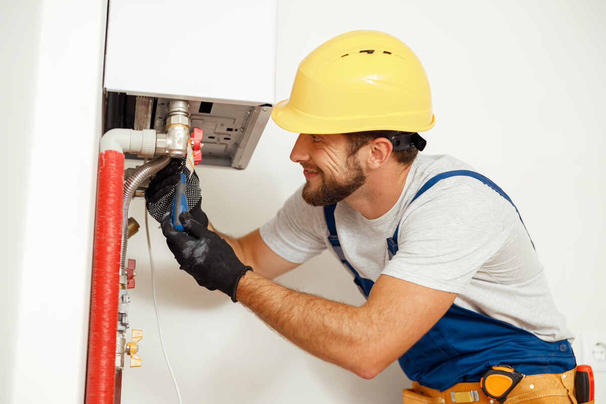 handsome man fixing boiler or water heater